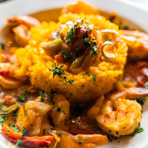 Close-up of a vibrant shrimp and rice dish, garnished with fresh parsley at 354 Steakhouse.